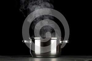 Steaming pot on black background