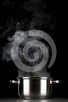 Steaming pot on black background