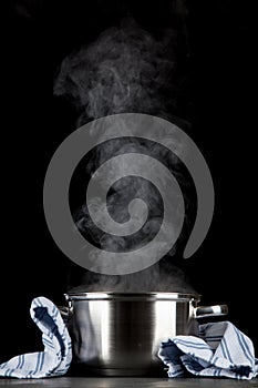 Steaming pot on black background
