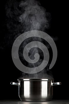 Steaming pot on black background