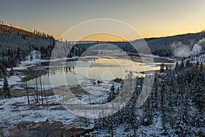 Steaming vents and lake along a road in Yellowstone National Park, Wyoming