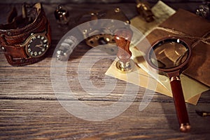 Steampunk still life - old vintage objects on a wooden background. Leather wrist watch, dark glasses, old tube lamps, magnifying g