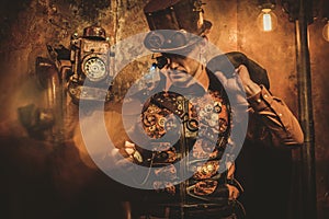 Steampunk style man with various mechanical devices on vintage steampunk background