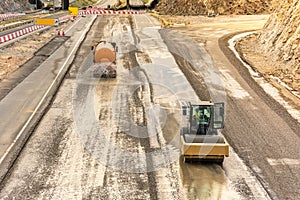 Steamroller doing road construction workPreparation of surface with water tank truck for asphalted