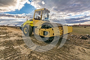 Steamroller performing leveling work on a road under construction