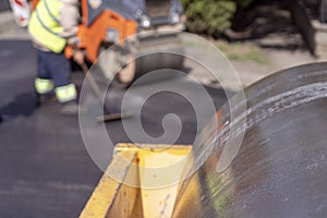 Steamroller and Road Construction Workers at Road Construction Site photo