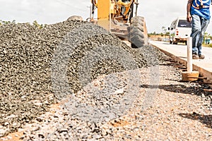 Steamroller spreading asphalt mixture during the construction of a road in Central America