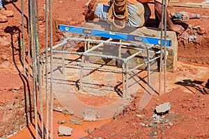 Steel bars and rebar wires are put into trenches at the construction site so as to reinforce concrete foundations with