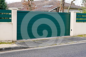 Steel big green metal gate fence on modern house street