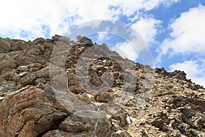 Steel cable from a via ferrata in a mountain rock face towards Saulkopf, Hohe Tauern Alps