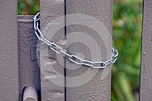 Steel chain hanging on a gray iron gate