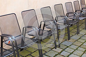 Steel chairs against old textured cement wall