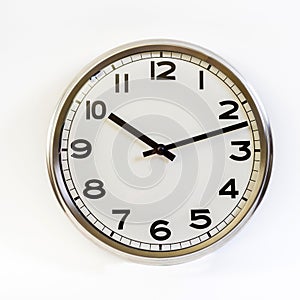 A steel clock on a white background shows ten hours and twelve minutes