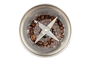 Steel coffee grinder with a small amount of coffee beans isolated on white background