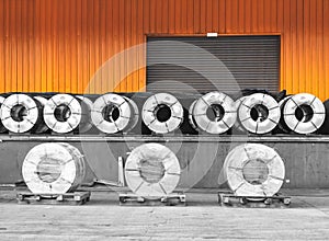 Steel coils on wooden pallets in warehouse stuffing area for container stuffing.