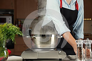 Steel cooking pan on electric hob with boiling water