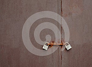 A steel door locked with two padlocks.