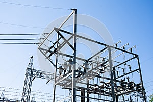 Steel electric poles and lines in High voltage electric power station against sun shine and clear blue sky