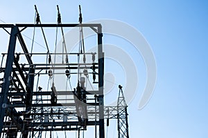 Steel electric poles and lines in High voltage electric power station against sun shine and clear blue sky