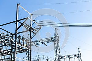 Steel electric poles and lines in High voltage electric power station with sun shine and clear blue sky