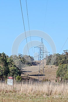 Steel electricity tower with low hanging wires and danger sign