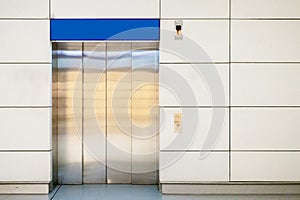 Steel elevator cabins with closed doors at business lobby