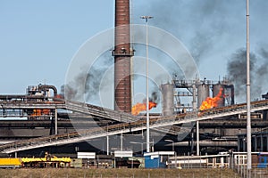 Steel factory with smokestack and gas flaring