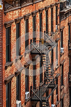 Steel fire stairs on the exterior of a brick flat building in New York Manhattan