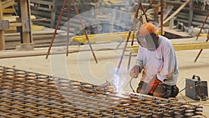 Steel Frame Construction. A welder welds a metal structure. Construction welder. Welding metal construction.