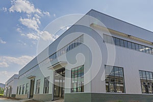 The steel frame structure factory building under construction is under the blue sky