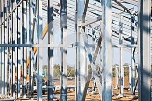 Steel frame workshop is under construction against a blue sky