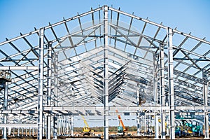 Steel frame workshop is under construction against a blue sky