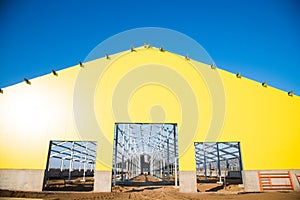 Steel frame workshop is under construction against a blue sky