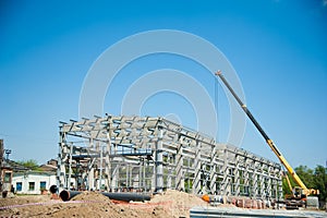 Steel frame workshop is under construction against a blue sky