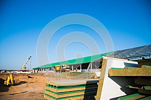 Steel frame workshop is under construction against a blue sky