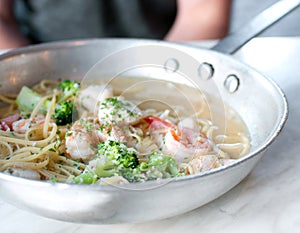 Steel frying pan with spaghetti and shrimps