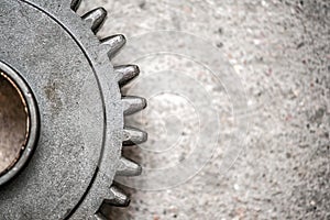 Steel gears on grey concrete background with copy space. Close up