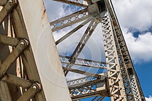 Steel girders on a bridge with white clouds and blue skies