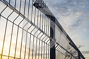 Steel grating fence made with wire on blue sky background. Sectional fencing installation.