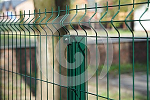 Steel grating fence made with wire on garden background. Sectional fencing installation.