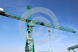 Steel green high crane under blue sky