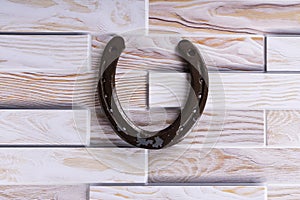 Steel horseshoe on a wooden background, brings luck, symbol