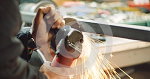 Steel industry - man using angle grinder grinding metal object at workshop.