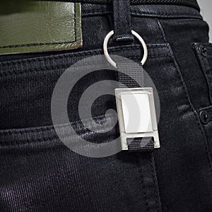 Steel key ring hanging on black jeans. Blank key chain for your design. Souvenir or accessory. Can put text, image, and logo