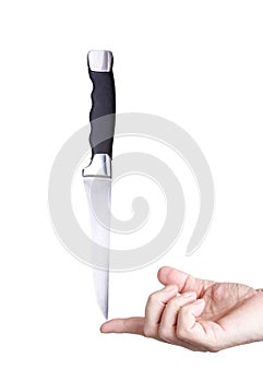 Steel knife balanced on the finger isolated on white background