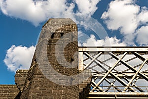 Steel lattice construction of a railway bridge on a background of blue sky with white clouds.