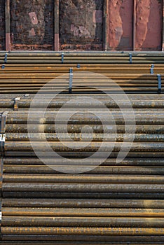 Steel, many round steel bars transversely in the steel bearing outdoor in front of railway waggon, metal bundled with steel strip,