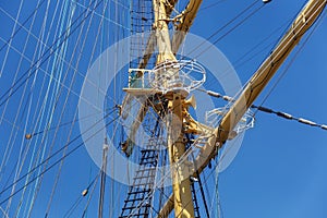 Steel masts of a sailing ship with the lowered sails.