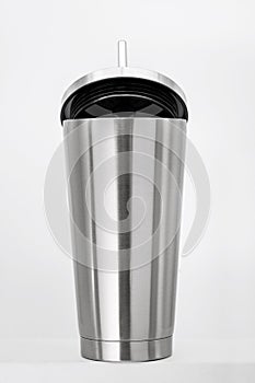 Steel mug on white shelf. Blank stainless tumbler for your design. Insulated bottle for keep your drink