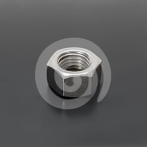 Steel nut on a gray background. Side view